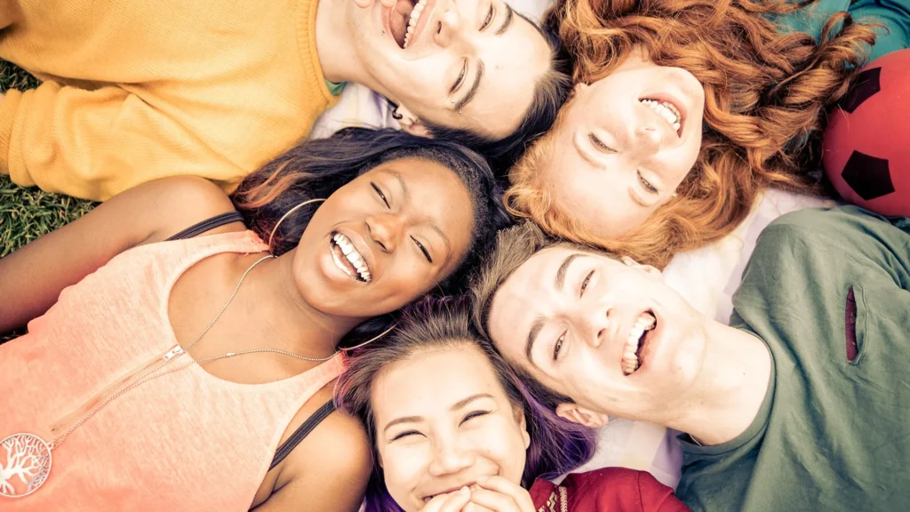 Grupo de estudiantes tumbados mirando a cámara